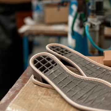 Sample photo, after: new rubber soles ready to fit on a cobbler bench