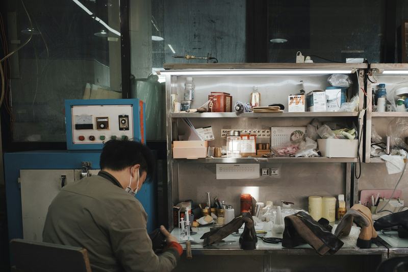 Sample photo: a cobbler working at a cluttered repair bench